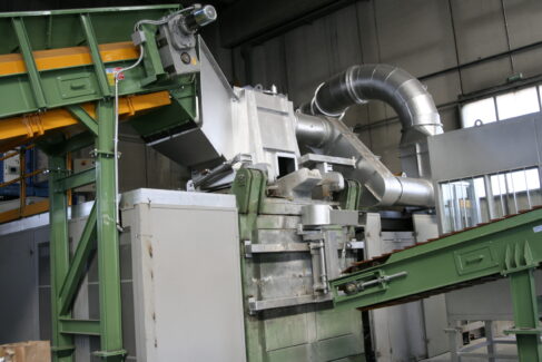 Cappa aspirante Ghirarduzzi installata su forno fusorio industriale con sistema di aspirazione fumi e canalizzazioni in acciaio per la depurazione dei gas di fusione.