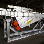 Industrial vibrating channel built by Ghirarduzzi for transporting, dosing, and screening small-sized materials. Made of robust steel with lateral vibrating motors and minimal maintenance needs.