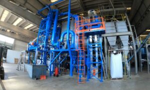 Angular view of a rubber granule separation plant with blue machinery and orange safety details, crafted by Ghirarduzzi srl.