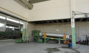 Industrial drying drum by Ghirarduzzi installed in a large industrial plant, designed for drying materials such as brass granules, aluminum and zama turnings, calcium carbonate, plastics, sands, and aggregates. The robust and efficient drying system is shown in a spacious, well-ventilated industrial setting.